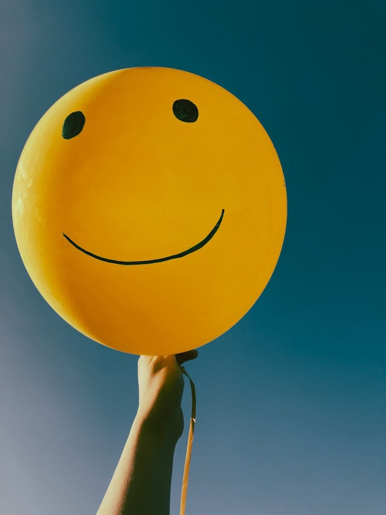 Close-Up Shot of a Person Holding a Yellow Balloon